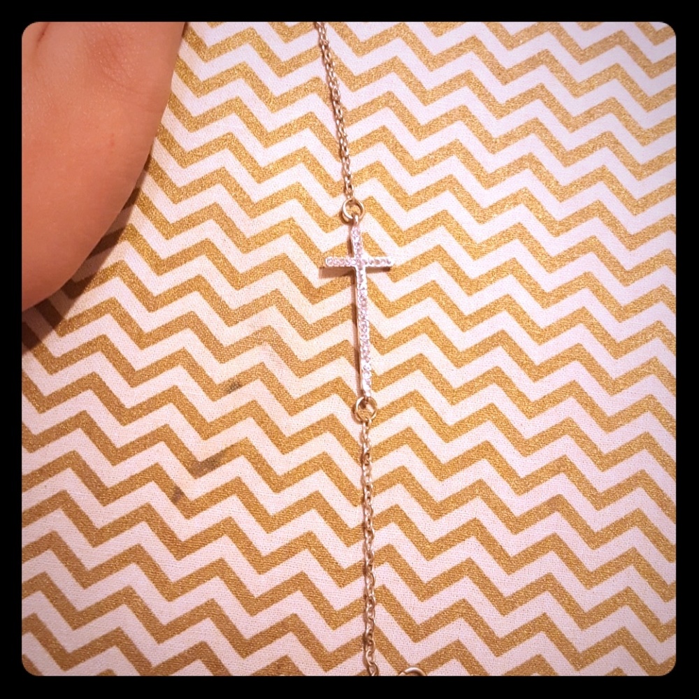 A cross bracelet with gems on it